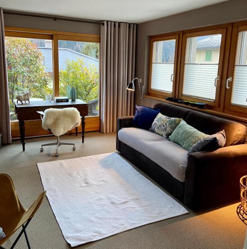 a living room with a couch and a table and a piano at Villa Fleurettes STUDIO in Le Châble