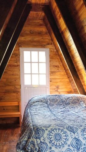 a bedroom with a bed in a attic with a window at Cabaña Capitán Viruta in Rosario