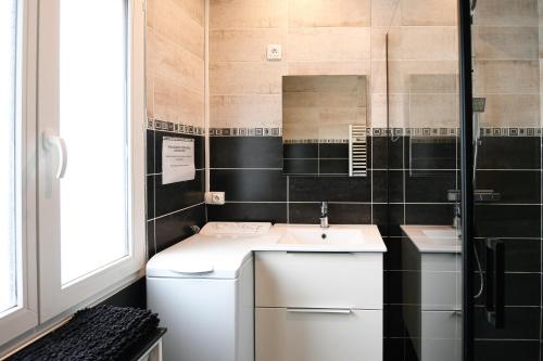 a small bathroom with a sink and a mirror at Gîte Maison de pêcheur in Le Crotoy