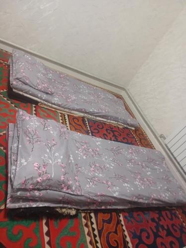 two purple umbrellas sitting on top of a rug at Abylay Guesthouse in Jangy-Talap