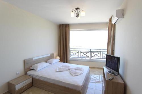 a bedroom with a bed and a large window at goldenseaview in Pomorie