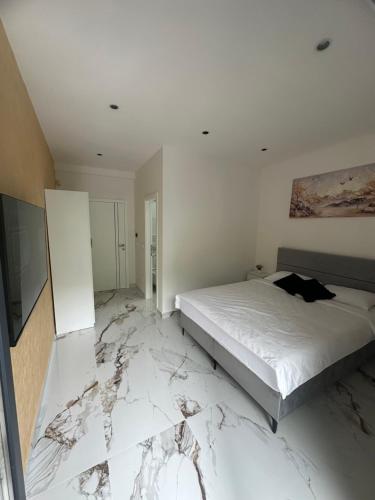 a bedroom with a bed and a marble floor at Villa Imperium Indoor & Outdoor Pool Riverfront Bjelašnica View in SJJ
