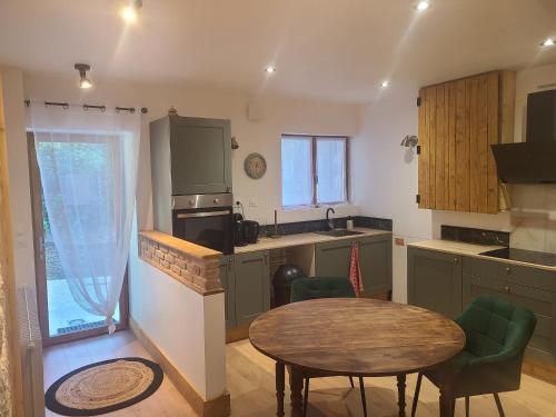 a kitchen with a table and a small kitchen with a table and chairs at Le Roche-Velours in Paray-le-Monial
