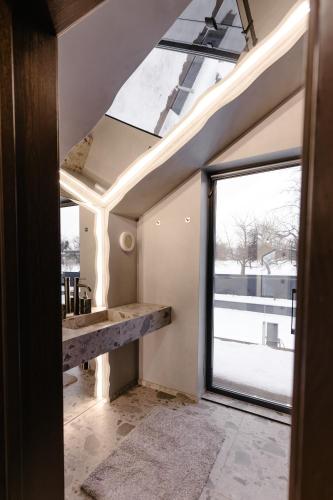 an attic room with a large window and a table at Liso Prostir in Lisopotik
