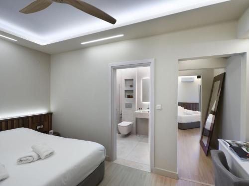 a white bedroom with a bed and a bathroom at Ktima Faki, The One & Only Destination on Mount Olympus in Litochoro