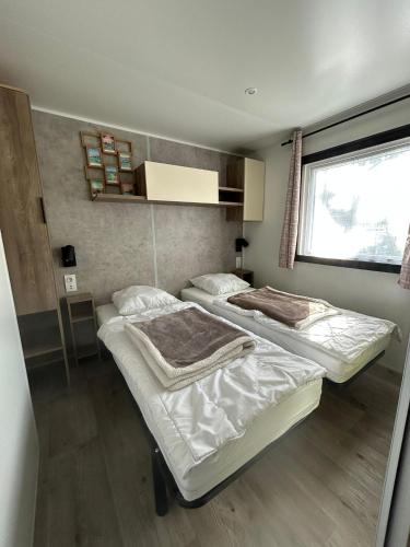 a room with two beds and a window at Camping du CONGUEL in Quiberon