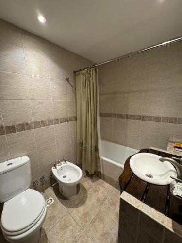a bathroom with a toilet and a sink and a tub at Villa Ostende Apart Hotel & Spa in Ostende