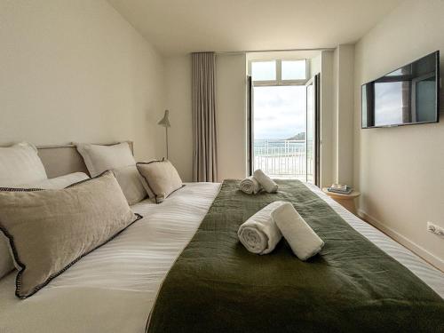 a bedroom with a large bed with towels on it at Coasteres T2 in Trébeurden