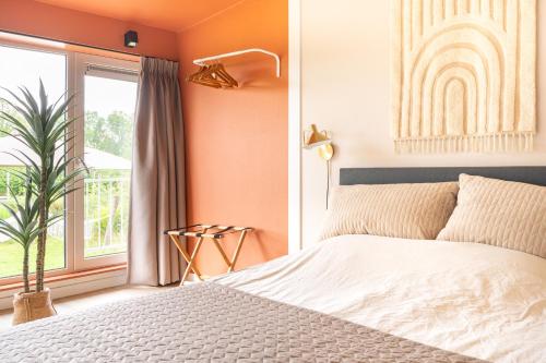 a bedroom with a white bed and a window at Tiny House XL | 2 persons in Gasselte