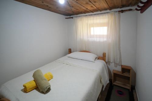 a bedroom with a white bed and a window at Kulla e Sadri Lukes in Theth