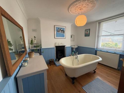 a bathroom with a tub and a sink and a mirror at Charming Town House Central Margate in Margate