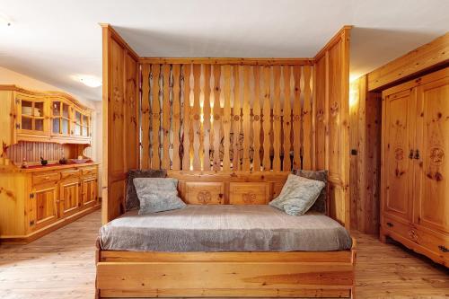 a bedroom with a bed in a wooden wall at Petit Logement Cerise L'écrin d'Ari in Cerise