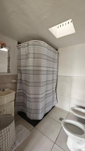 a bathroom with a shower curtain and a toilet at Bell Ville in Bell Ville