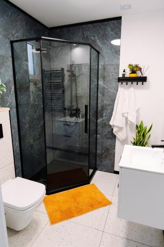 a bathroom with a shower and a yellow rug at 4 Pory Roku in Darłowo