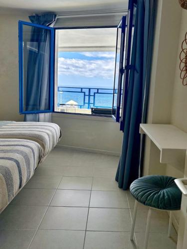 a bedroom with a window with a view of the ocean at Fish & Banana Beach House in Taurito