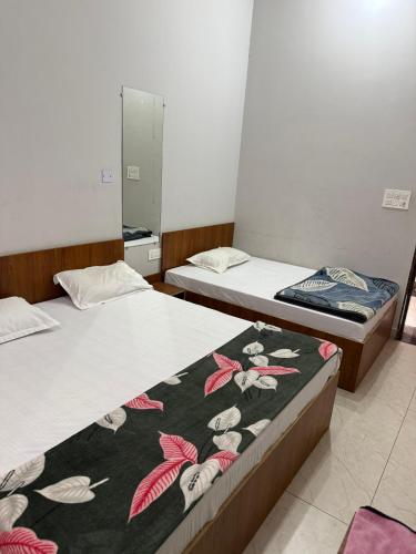 two beds in a room with a blanket on them at RADHA DEVI GUEST HOUSe in Juliāsar