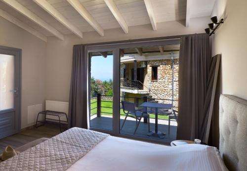 a bedroom with a bed and a sliding glass door at Ktima Faki, The One & Only Destination on Mount Olympus in Litochoro