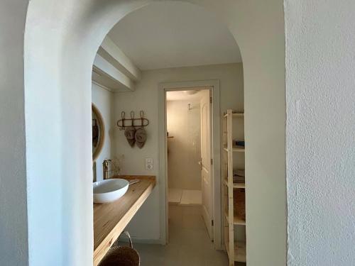 a white bathroom with a sink and a mirror at Fish & Banana Beach House in Taurito