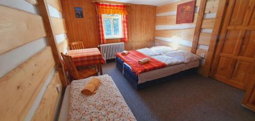 a bedroom with a bed and a table and a chair at Chata Betyna in Pec pod Sněžkou