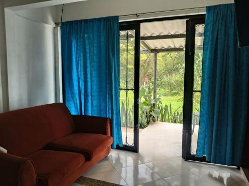 a living room with a couch and blue curtains at Hotel campestre terrazas y sol in La Vega