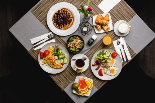 ein Tisch mit Tellern mit Frühstücksspeisen in der Unterkunft Focus Hotel Łódź in Łódź