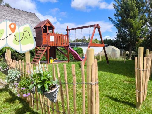 a wooden fence with a playground in a yard at Ferienwohnung am Soonwald in Ellern