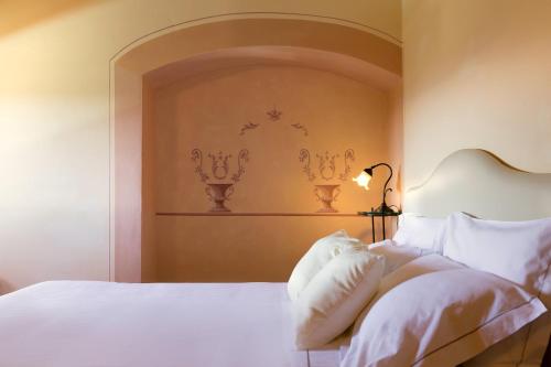 a bedroom with a white bed with a headboard at Palagina la dimora in Figline Valdarno