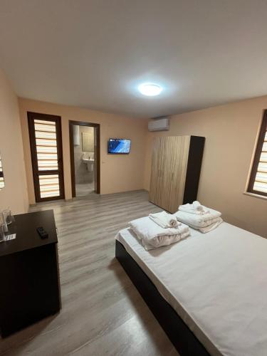 a bedroom with a bed with two towels on it at Червената къща in Hisarya