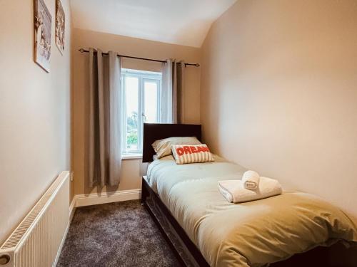 a bedroom with a bed with two pillows on it at Rothsay Beach House in Newbiggin-by-the-Sea