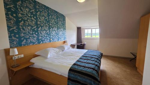 a bedroom with a bed with a blue and white wall at Hotel Gerardushoeve in Heijenrath