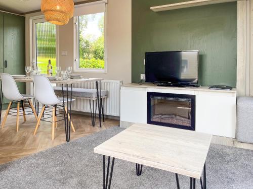 a living room with a fireplace and a tv at Forest Sherman - Uk50089 in Durham