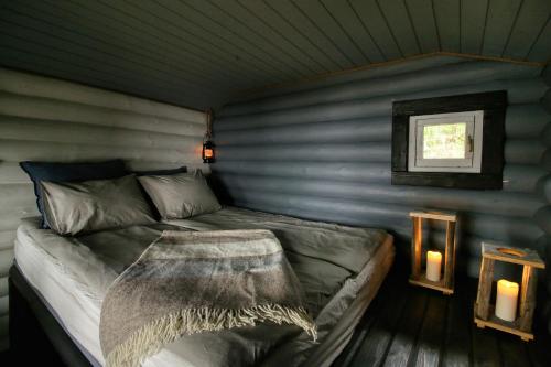 a bedroom with a bed in a room with two candles at Experience Finland Like a Finn-Private Island Tampere Region in Orivesi