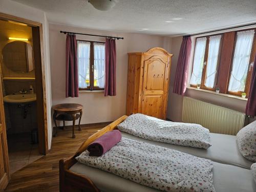 a bedroom with two beds and a sink and windows at Haus zur Ölmühle 2 in Steinsfeld