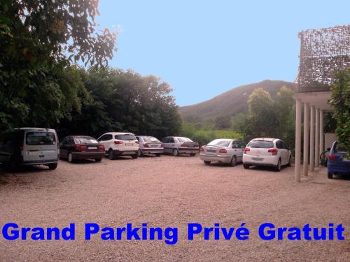 a bunch of cars parked in a parking lot at Villa Les Martinets-Chambres Climatisées-Parking Privé-Piscine-Jacuzzi-Brise Fraîche de la Montagne in Le Poujol-sur-Orb