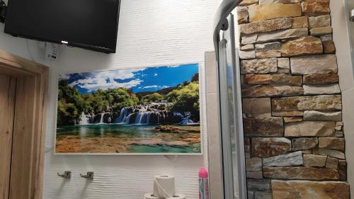 a painting of a waterfall on the wall of a bathroom at Ferienwohnung Daun in Daun