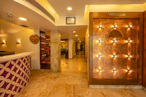 a lobby with a wooden door with lights on it at La Woods Hotel in Chennai