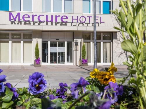 a building with purple flowers in front of it at Hotel Mercure Graz City in Graz