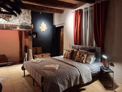a bedroom with a large bed with red curtains at B&B maison du Saint Cirque in Saint-Dau