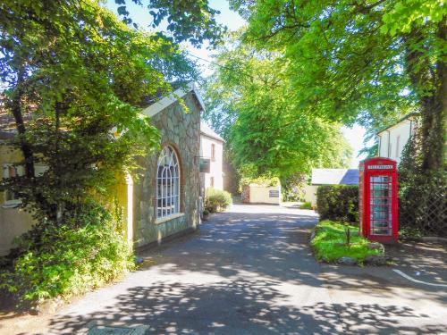 a street with a red phone booth and a building at The Garden Lodge Flat - Uk49415 in Pembrokeshire