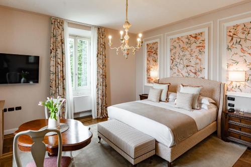 a bedroom with a large bed and a chandelier at Cappuccina Country Resort in San Gimignano