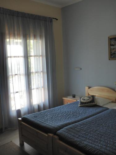 a bedroom with a bed and a large window at Felicita in Paleokastritsa
