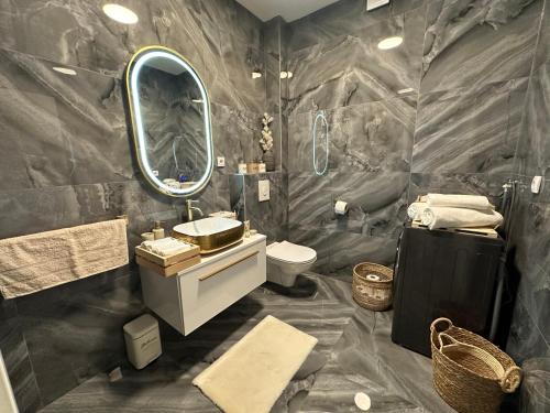 a bathroom with a sink and a toilet and a mirror at Novi apartman Posušje in Posušje