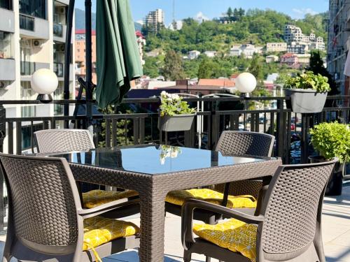 a table and chairs on a balcony with a view at Aurora Hotel Batumi in Batumi