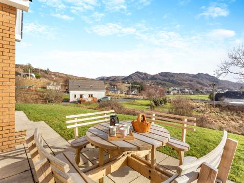 a wooden table and chairs on a patio at Bramble Cottage in Gairloch