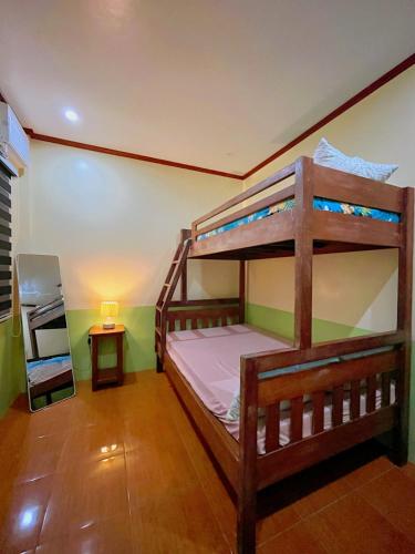 a bedroom with two bunk beds and a lamp at Marianne's Guest House in New Agutaya