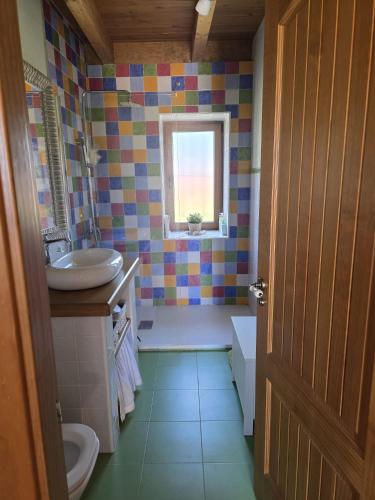 a bathroom with a sink and a toilet and a window at Las Fonderas in Cuadros