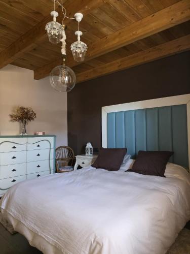 a bedroom with a large white bed with a blue headboard at Las Fonderas in Cuadros