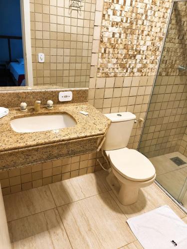 a bathroom with a toilet and a sink at Hotel Teofilo Otoni in Teófilo Otoni