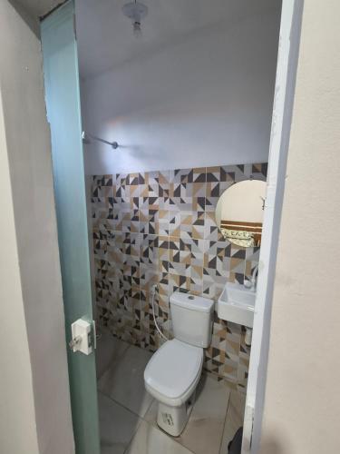 a small bathroom with a toilet and a sink at Descanso das Águas in Santo Amaro