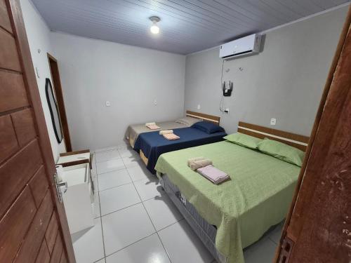 a room with two beds in a room with a door at Descanso das Águas in Santo Amaro